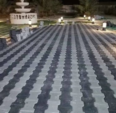 تركيب بلاط متداخل (إنترلوك) لتجهيز ممر حديقة بالكويت، يظهر مع إضاءة أرضية ونافورة