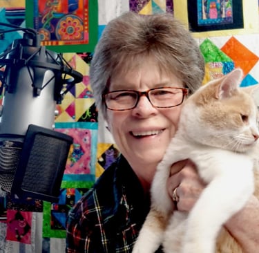 a woman in glasses and a plaid shirt is holding a cat