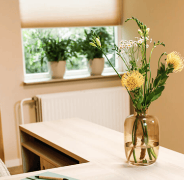 Een mooie bloemenvaas op het bureau in de praktijkruimte van Refunction