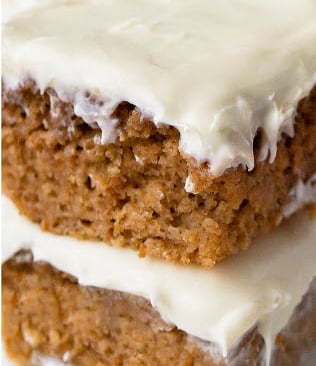 a close up of a piece of applesauce cake with frosting cream cheese 