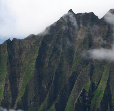 a mountain with in Hawaii with clouds