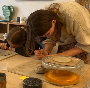 Two young girls making slab built mugs at a pottery class in Bristol