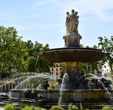 The historic Fontaine de la Rotonde in Aix-en-Provence featuring stone statues and water jets.