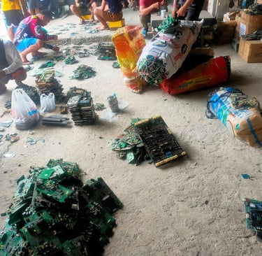 a group of people standing around a pile of broken electronics