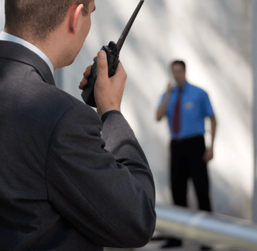 Force Prévention Sécurité – Agent de sécurité en costume noir, équipé d'oreillettes et de lunettes de soleil, assurant la sur