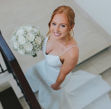Elegant bride holding white rose bouquet after professional wedding hair and makeup