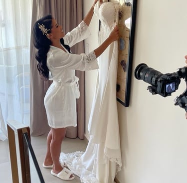 Bride in a white robe getting her wedding dress ready before the ceremony