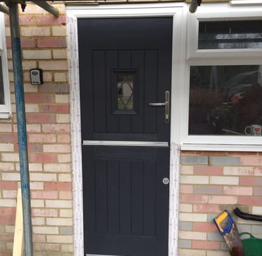 Black stable door with small leaded glass panel