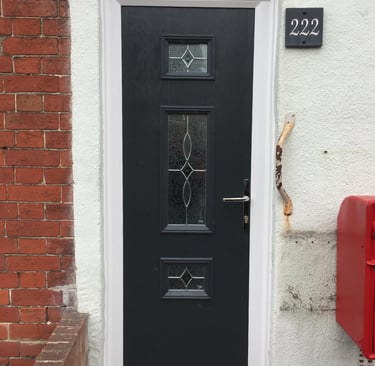 a thin front door fitted on a terrace house in Portsmouth by buildmydoor. black with pattern glass.