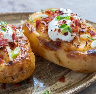 Golden-brown potato skins filled with creamy whipped potatoes, topped with melted cheese and crispy 