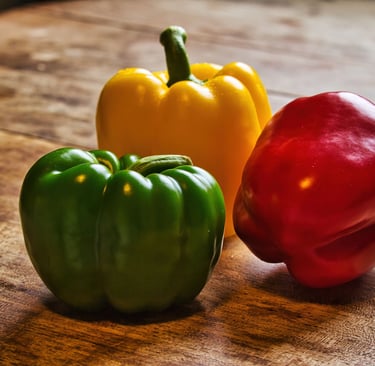 three peppers peppers on a wooden table