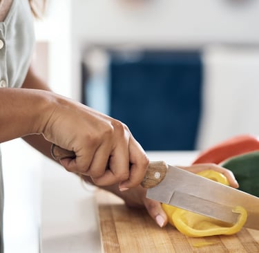 Woman cutting a bellpepper on a chopping board