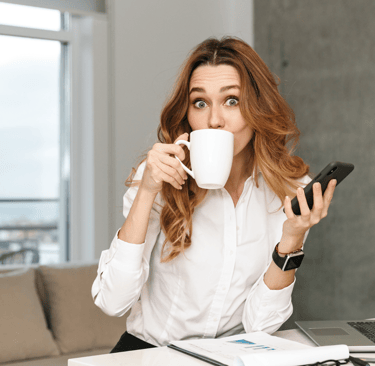 a woman sitting at a desk with a cup of coffee