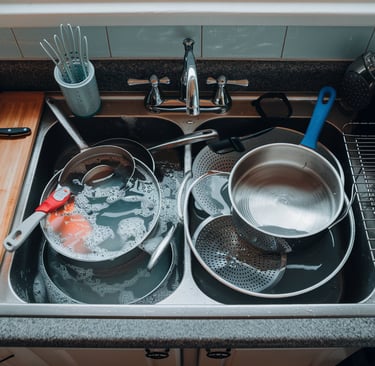 a kitchen sink with pots and pans of cooking utensils