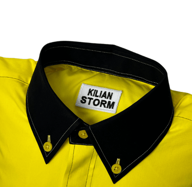 a yellow shirted pillow with a black collar and label
