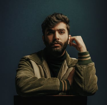 a man sitting in a chair with his hand on his chin