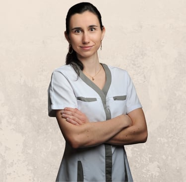 Pauline Royer Ostéopathe portrait en blouse, les bras croisés sur son buste, avec un fond beige