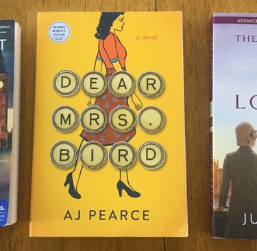 three books on a table with a clock and a clock