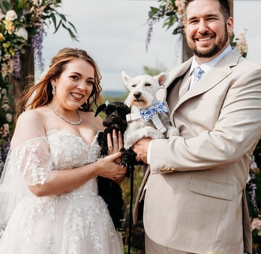 a man and woman holding a dog in a wedding ceremony