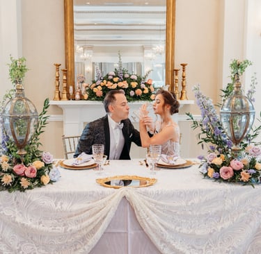 a man and woman sitting at a table with flowers