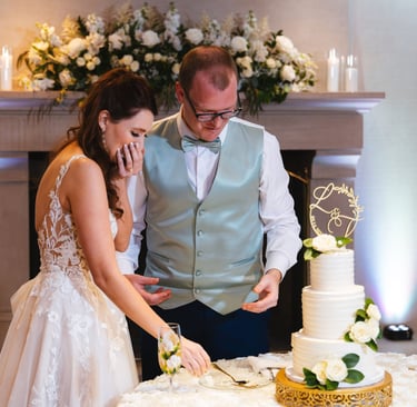 a man and woman cutting their wedding cake