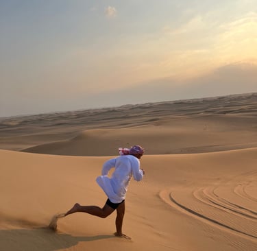 a man in a white shirt is running through the desert