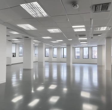 A worker is suspended on ropes, cleaning the windows of a large brick building. The person is equipped with cleaning gear, including a brush and a safety harness attached to a bucket of supplies. The window panes have visible streaks being cleaned, contrasted against the industrial background of brick and metal.