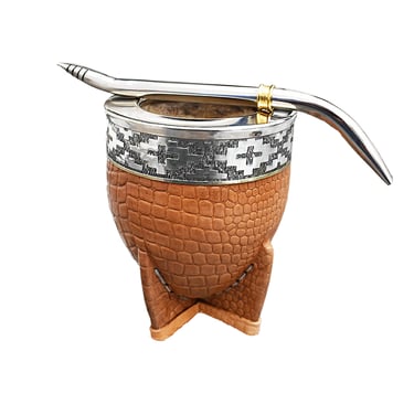 Handcrafted leather mate gourd with silver rim and stainless steel bombilla straw on a white background.