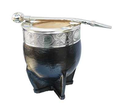 Handcrafted black leather yerba mate gourd with an ornate silver rim and a metal bombilla straw.