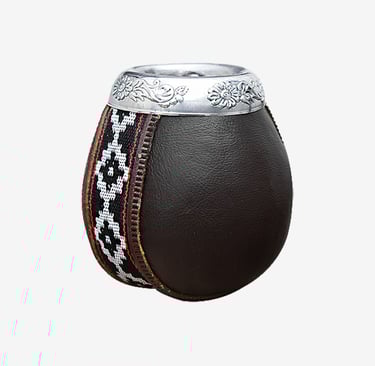 Traditional leather-wrapped yerba mate gourd with silver floral rim and woven geometric pattern.