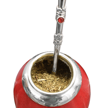 Close-up of a vibrant red calabash gourd filled with yerba mate tea and a decorative silver bombilla, set against a dark
