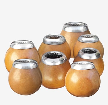 A collection of traditional wooden yerba mate gourds with polished silver rims.