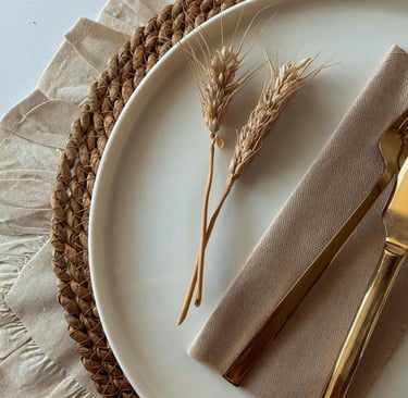 “Dining table with woven placemats, linen napkins, and ceramic plates for a modern rustic look.”