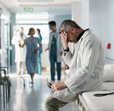 frustrated healthcare worker sitting on gurney in hospital hallway