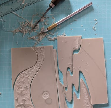 a jigsaw linocut print being assembled with printmaking tools on desk