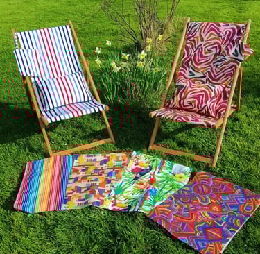 Deux chiliennes posées sur une pelouse avec un tissu rayé bleu et un autre à motifs roses