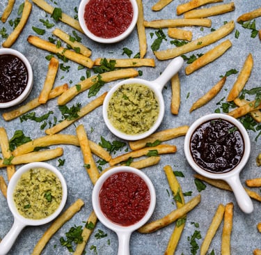 Sustainable plant-based sauces displayed in small white dishes with potato chips surrounding