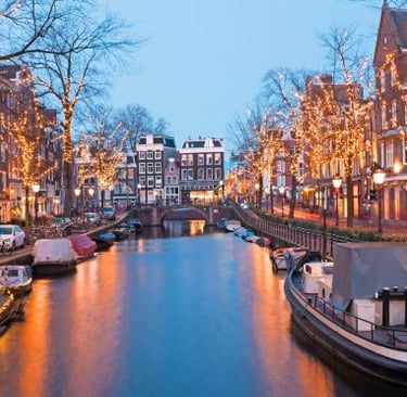 a canal with boats and christmas lights on it