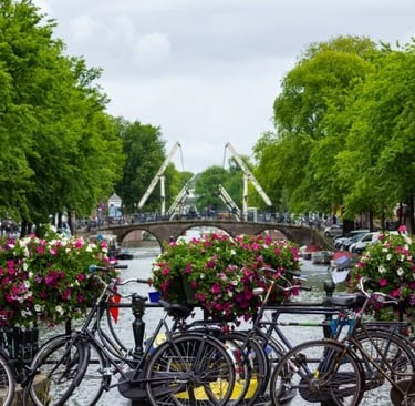 bicycles parked on a bridge over a river in amsterdam