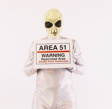 a man in a silver suit and sunglasses holding a sign that says area 515