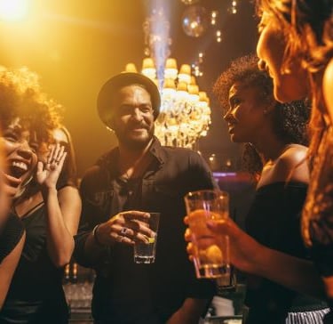a group of people standing around a bar