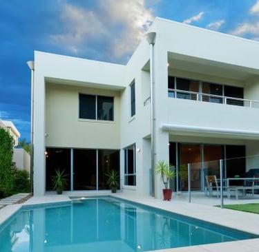 a house with a pool and a pool in the background