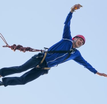 a man in a blue jacket is flying through the air