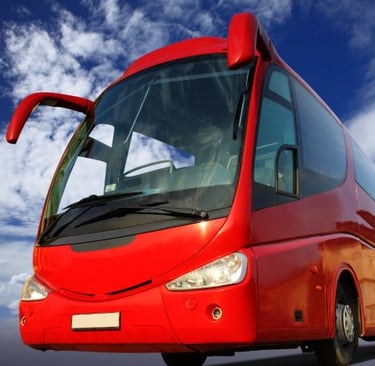a red bus is driving down the road
