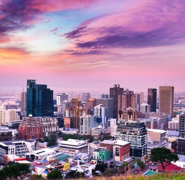 a city skyline with a sunset sky and a pink sky