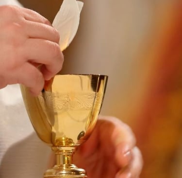 a catholic priest holding a golden cup with wine