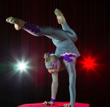 a woman doing a handstand on a stage