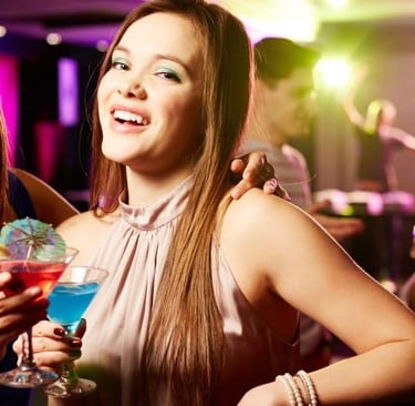 two women are smiling and having fun at a cocktail party