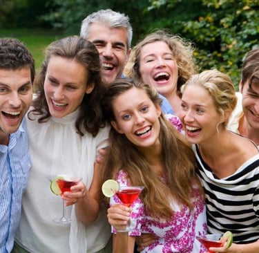 a group of people standing around a table with drinks