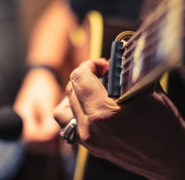 a man playing guitar in a recording studio